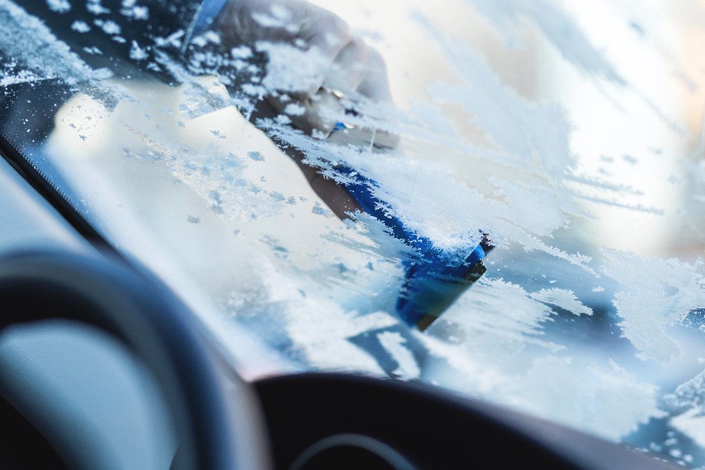 Scraping frost off a truck windshield